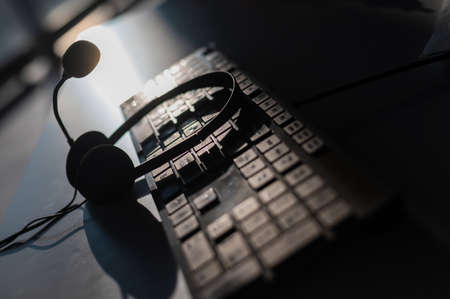 Headset with microphone on the computer keyboard. Call center operators workplaceの写真素材