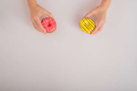 Female hands with donuts on a white background. Copy space.
