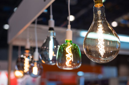 Many differently shaped incandescent bulbs are suspended in the dark