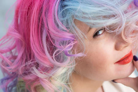 Close-up portrait of curly Caucasian woman with multi-colored hair. Model for hairstylesの写真素材