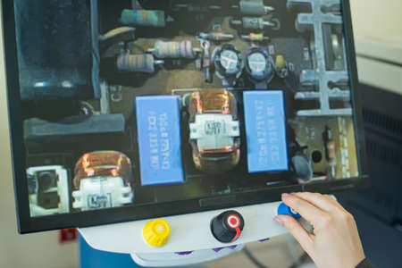 Woman examines microcircuits on a special apparatus for reading the visually impaired.の写真素材