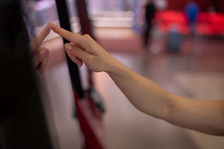 Close-up of female hand on touch screen information counter in shopping mall.の写真素材