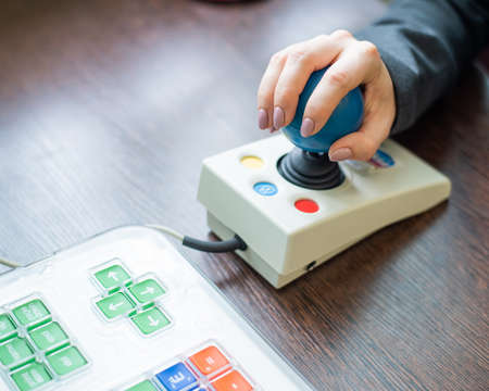 Woman with cerebral palsy works on a specialized computer mouse.