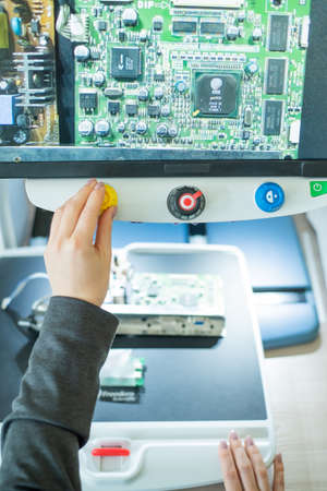 Woman examines microcircuits on a special apparatus for reading the visually impaired.の写真素材