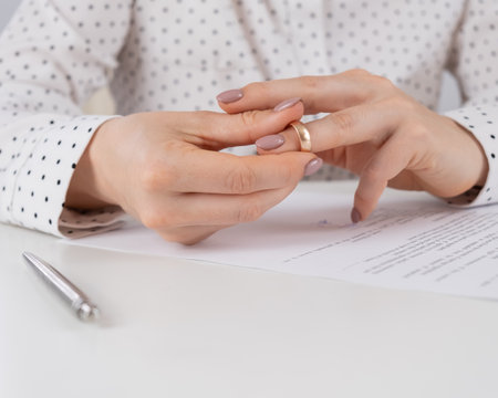Close-up woman signed divorce papers and took off her wedding ringの写真素材