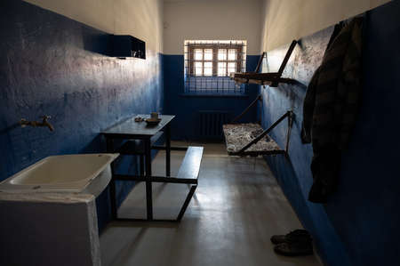 Empty double prison cell with bars on the window