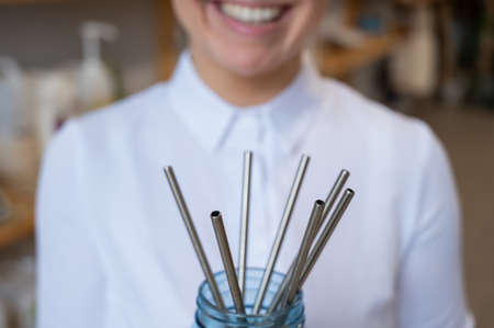A woman holds a jar of reusable steel tubes. Eco conceptの写真素材