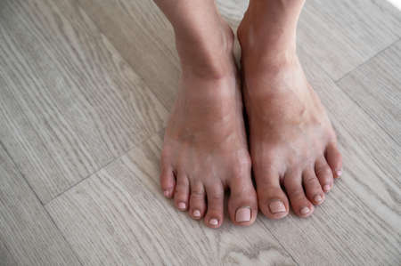 Close-up of tanned female legs with white stripes on the skin from sandals.の写真素材