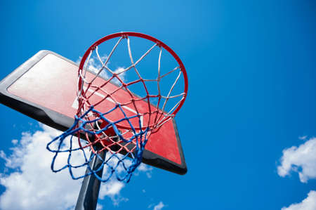 Bottom view of an empty basketball basket against the blue sky