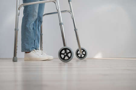 Close-up of female legs with walkers. The girl walks with the help of special equipment.