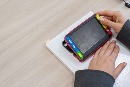 The woman is holding a reading device for the visually impaired. Electronic magnifier for the...