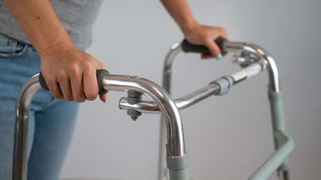 A woman is walking with a walker on a white backgroundの写真素材