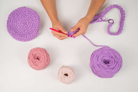 Close-up of a woman crocheting a basket of cotton yarn.の写真素材