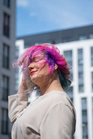 Close-up portrait of curly Caucasian woman with multi-colored hair. Model for hairstyles