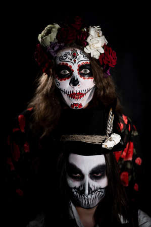 Woman in santa muerte costume and man in skeleton bodypainting for halloween.の写真素材