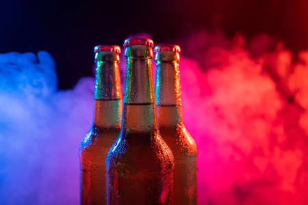 Three bottles of beer in a blue-pink mist.の写真素材