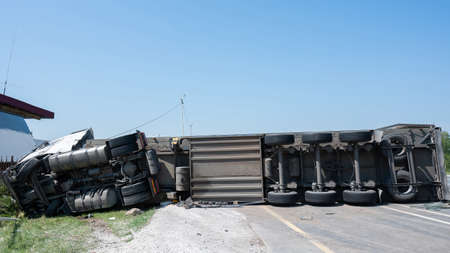 The truck is lying on its side in a car accident on the highwayの写真素材