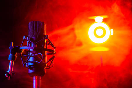 Professional microphone in red smoke on a black background.