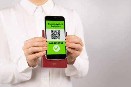Woman holding passport and phone with qr code about vaccination.の写真素材