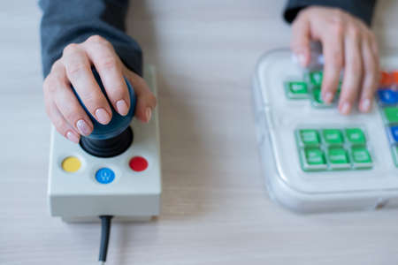 Woman with cerebral palsy works on a specialized computer mouse.