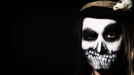 Young man wearing skull makeup in the dark. Halloween skeleton costumeの写真素材