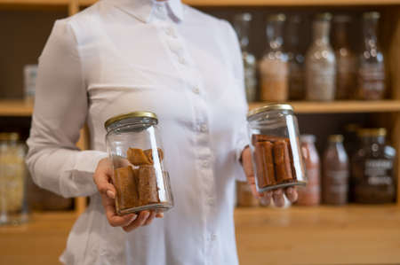 A woman holds a jar with Sweet pureed fruit pastila. Natural weight sweets in an eco storeの写真素材