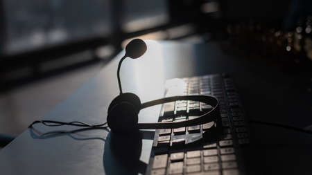 Headset with microphone on the computer keyboard. Call center operators workplaceの写真素材