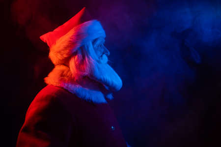 Santa claus in neon light on a black background. Christmas party.の写真素材