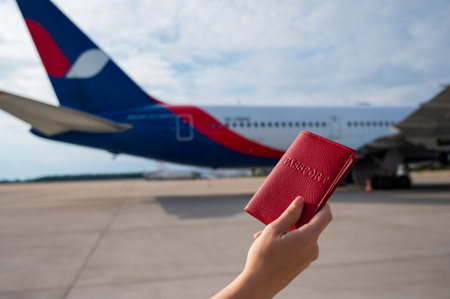 A woman gets on a plane and holds a passportの写真素材