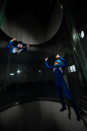 A man teaches a boy to fly in a wind tunnel. Lack of gravity.の写真素材