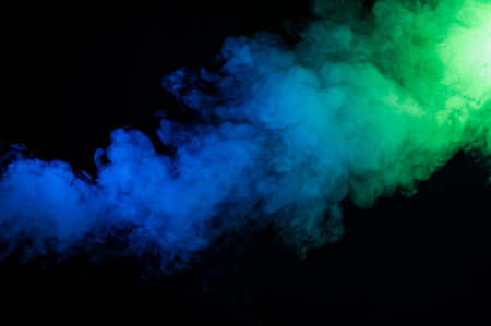 Green-blue smoke in neon light on black background.の写真素材