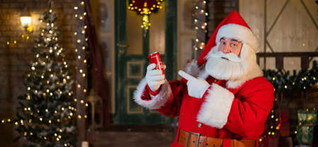 6.11.2020 Russia, Novosibirsk: Santa Claus holds a can of Coca Cola in his hands. Advertising of a coffee and sugar drink for christmasのeditorial素材