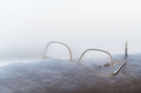 Womens glasses with white frames on the snowの写真素材