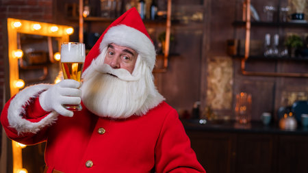 Santa Claus drinks beer while sitting in a leather armchairの写真素材