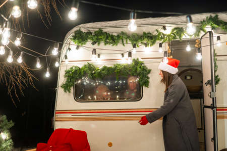 Caucasian woman and two with sons celebrate Christmas in a camper. Mom of two boys dress up the van.の写真素材