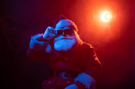 Santa claus in sunglasses in neon light on a black background. Christmas party.の写真素材