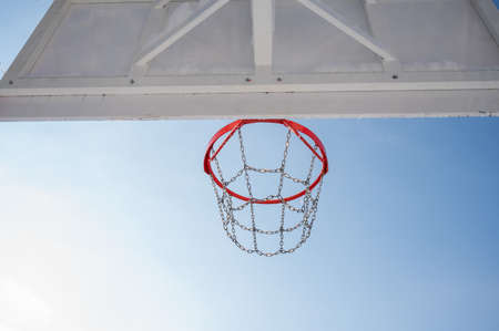 Bottom view of the background of a basketball hoop against the blue sky.の写真素材