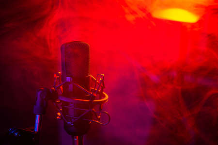 Professional microphone in red blue smoke on a black background.