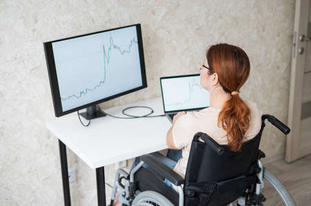 Caucasian woman on wheelchair working on laptop.