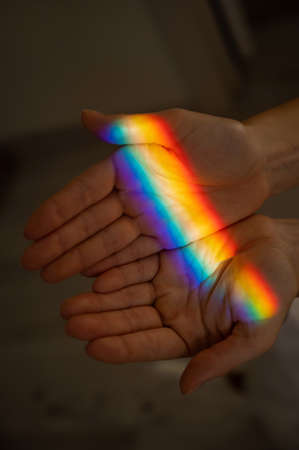 Rainbow ray on a womans hand.の写真素材