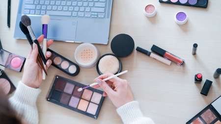 A faceless woman watches online training from a professional makeup artist on a laptop. Distance learningの写真素材