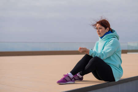 Caucasian woman in a sweatshirt measures her pulse after jogging.の写真素材