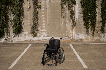 Empty wheelchair in open car parking in summer.の写真素材