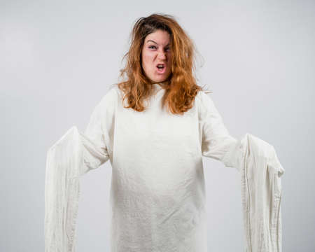 Close-up portrait of insane woman in straitjacket on white background.の写真素材
