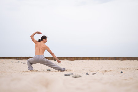 Caucasian man with long hair practicing qigong outdoors.