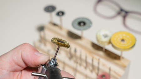 An optician technician polishes the frame of glasses. A professional optician fixes glasses.の写真素材