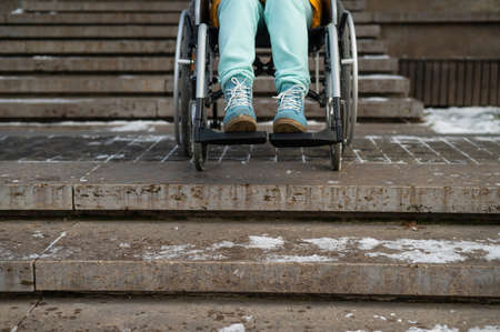 Woman in a wheelchair near the stairs in the park in winter.の写真素材
