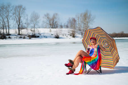Caucasian woman in a swimsuit sunbathes on the snow in winter.の写真素材