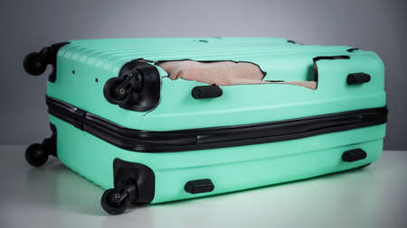 Mint damaged suitcase on a white background.の写真素材