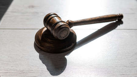 Wooden judicial gavel on a wooden laminate.